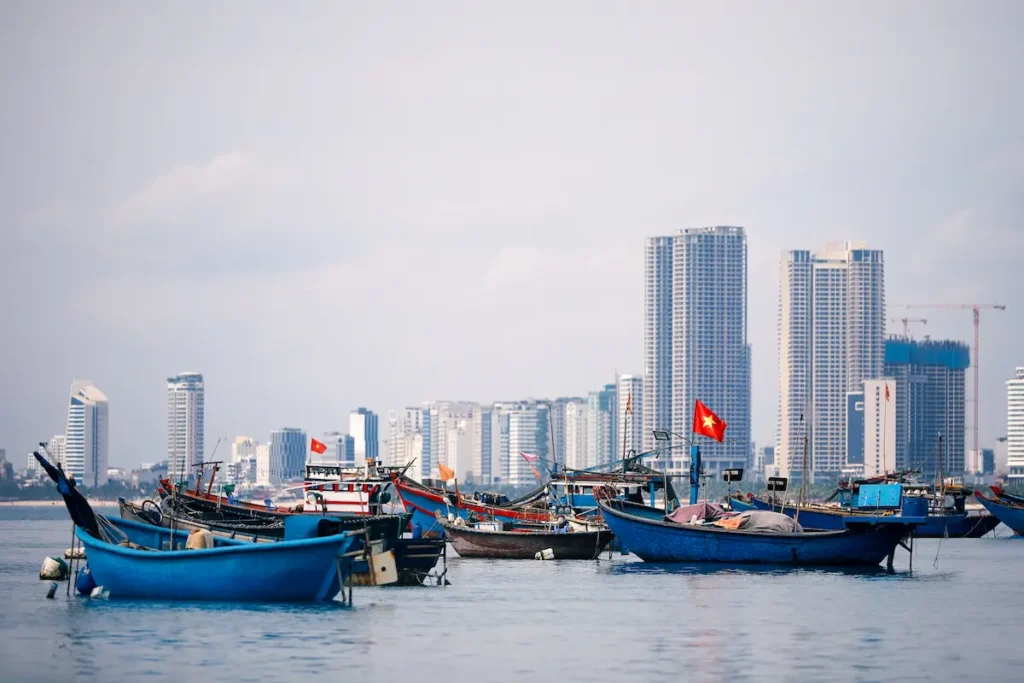 fishing-boats-moored-on-waters-with-city-skyline