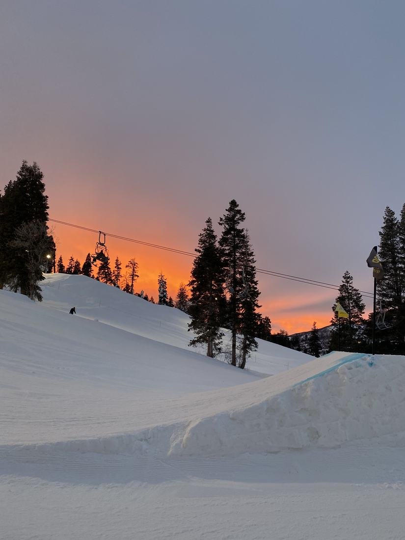 Atardecer naranja sobre las pistas y los pinos en Park City