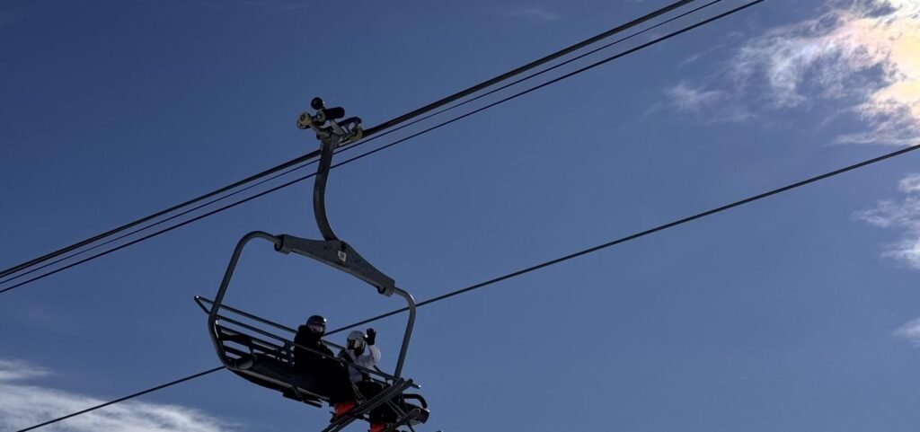 Telesilla con esquiadores contra el cielo azul en Park City